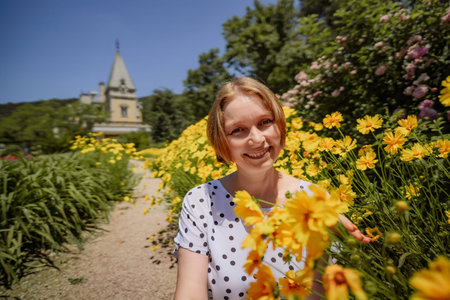 A woman is sitting in a field of yellow flowers
