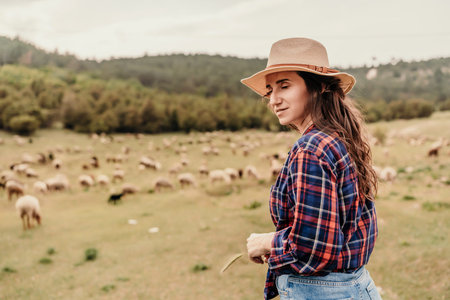 A woman wearing a straw hat stands in a field