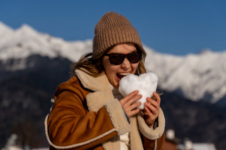 Snow Heart Mountains Woman Winter: playful snow heart, sunny alpine mountains, joyful winter activity.の写真素材