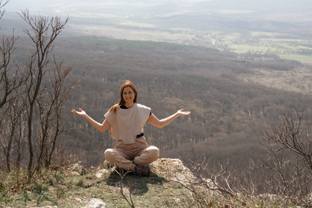 Woman Meditation Mountain: Woman meditates on a mountain top during daytime to find inner peace.の写真素材