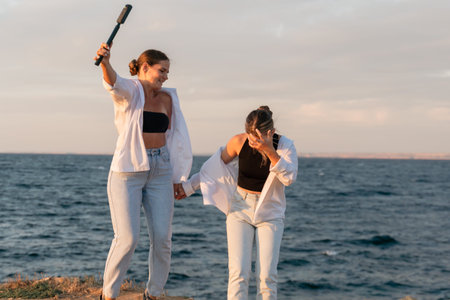Beach Women Friends Fun - Two women are laughing and having fun on the beach at sunset.