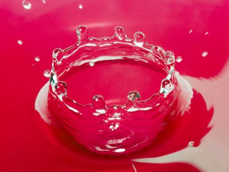 Red water bowl ( cup ) created by the fallen dropの写真素材