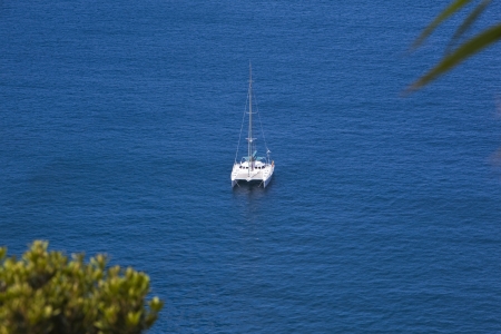 catamaran at anchor in a bay at sao miguel azores - yacht anchoring at a inlet on sao miguel azores portugalの写真素材