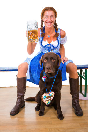woman in bavarian style with dog and beerの写真素材