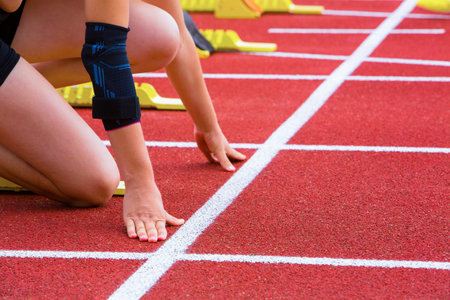 runner with arm injury at starting line on the track