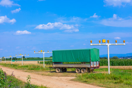 landing lights of an airport and tractor trailer on the fields in the summerの写真素材