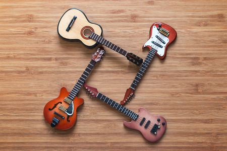Set of four guitars on a wooden backgroundの写真素材