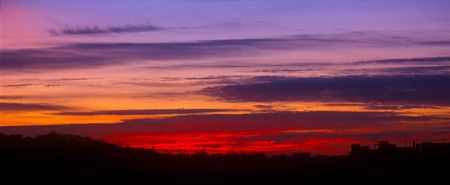 Sunset beyond the city with beautifully lit clouds.の写真素材