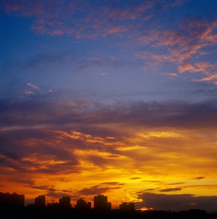 Landscape with houses silhouetted against a sunset.の写真素材