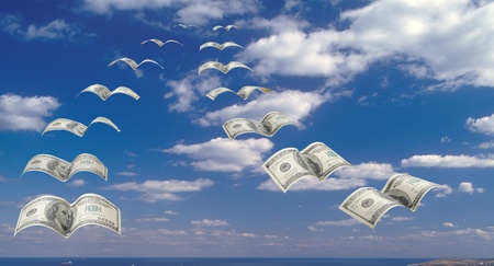 A flock of $100 banknotes in the blue sky.の写真素材