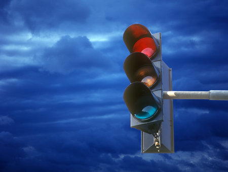 Traffic light  against the blue cloudy sky.