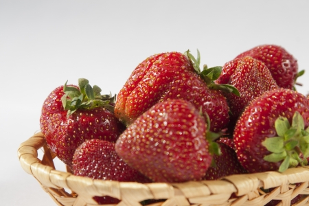Fresh organic strawberries in a wattled basket.の写真素材