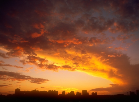 Beautiful golden sunset over a dark cityscape.の写真素材
