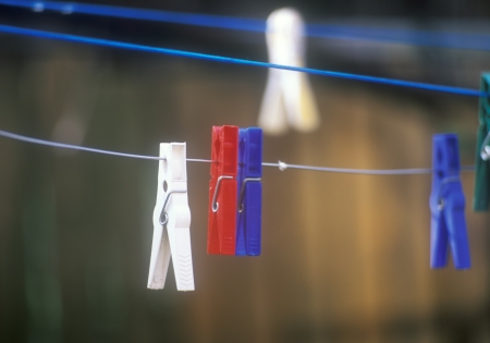 Multi colored clothespins hanging on the clothesline の写真素材