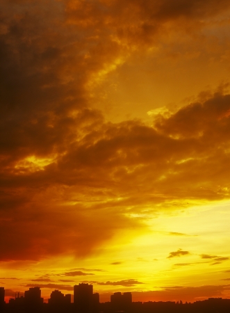 Beautiful golden sunset over a dark cityscape の写真素材