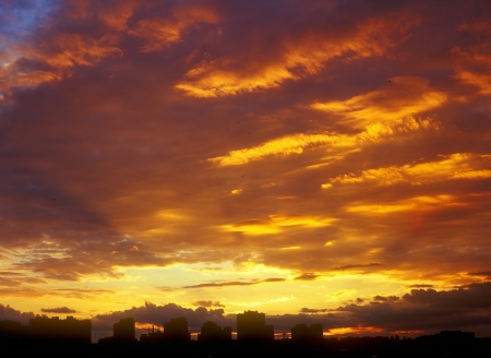 Beautiful golden sunset over a dark cityscape の写真素材