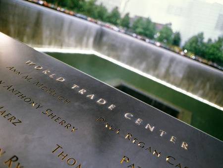 New York City, USA - June 24, 2014: 9/11 Memorial at Ground Zero, Lower Manhattan, commemorating the terrorist attack of September 11, 2001. Names of victims engraved in the bronze parapet.のeditorial素材