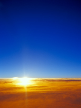 Sunset over a clouds. View from aircraft window.の写真素材