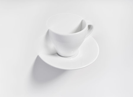 Half a cup with saucer in a white background.