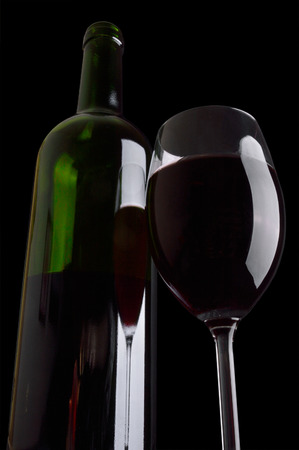 Bottle and wineglass of red wine on black background.の写真素材