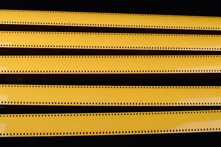 Yellow film on the black background.の写真素材