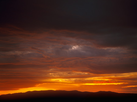 Ominous dramatic sunset over a dark landscape.の写真素材