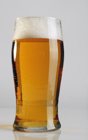 A glass of light beer on gray background.の写真素材