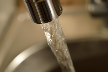 Close-up of running water from a faucet.の写真素材