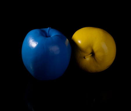 Yellow apple and blue apple on black background.の写真素材