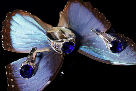 Beautiful gold ring and earrings with blue gemstones on a butterfly wings.の写真素材