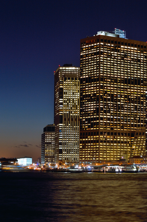 Lower Manhattan at night with blue sky and illuminated buildings.のeditorial素材