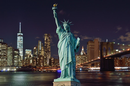 Collage - Manhattah skyline with Brooklyn Bridge at night and Statue of Liberty.の写真素材
