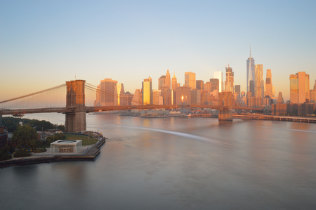 Manhattan skyline with Brooklyn Bridge at sunrise.の写真素材