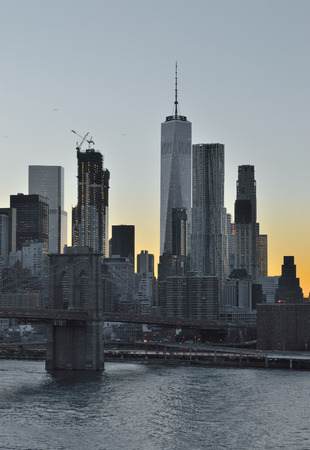 View of Manhattan skyline with Brooklyn Bridge at sunset.の写真素材
