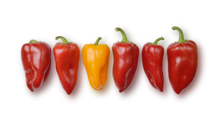 Red and orange bell peppers in a row isolated on white. Clipping path included.
