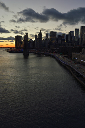 View of Lower Manhattan with Brooklyn Bridge at sunset time.の写真素材