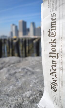 New York City, USA - February 3, 2019: The New York Times newspaper against a Lower Manhattan skyline.のeditorial素材