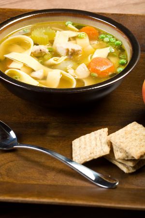 Hearty chicken noodle soup with crackers perfect for a cold dayの写真素材
