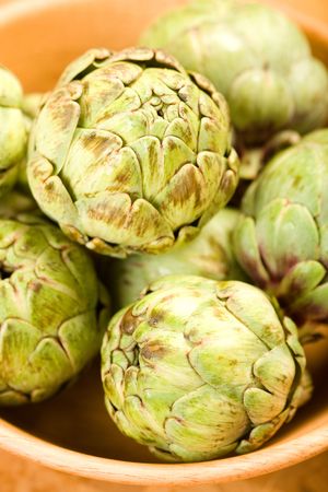 Baby artichokes in wooden bowlの写真素材