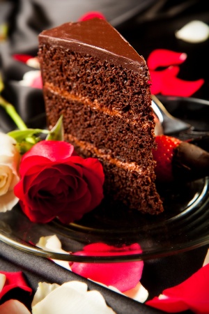 Rich dark choclate cake with mousse filling accompanied by chocolate covered strawberries and champagneの写真素材