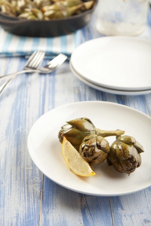 Baby artichokes roasted simply and served with lemonの写真素材