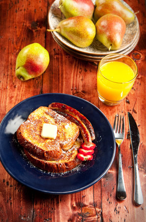 Sausage accompanies French toast in a delicious breakfastの写真素材
