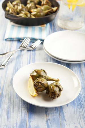 Baby artichokes roasted simply and served with lemonの写真素材