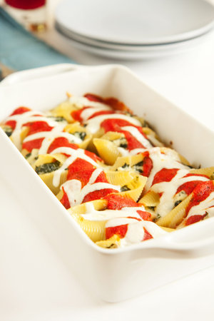 Stuffed pasta shells in white baking dishの写真素材