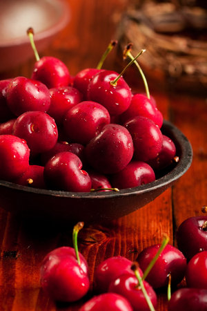 fresh juicy cherries in a rustic bowl. Focus on cherries in bowl.の写真素材