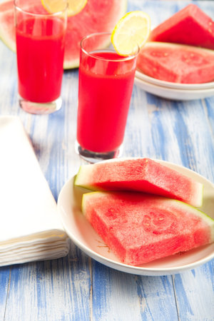 Just in time for summer a watermelon overload! watermelon wedges with cold watermelon punch.の写真素材