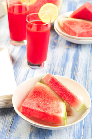 Just in time for summer a watermelon overload! watermelon wedges with cold watermelon punch.の写真素材