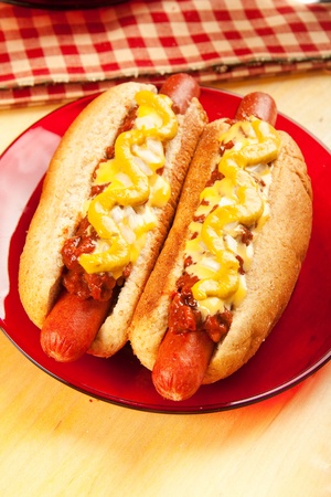 Perfect for the big game,  picnic, party or anytime, chili cheese dogs with mustard and onionsの写真素材