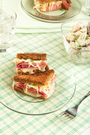 Traditional reuben sandwich cut into quarters served with potato saladの写真素材