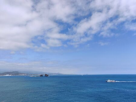 Breathtaking landscape shot of blue sea and cloudy sky in Jeju Island, South Koreaの写真素材